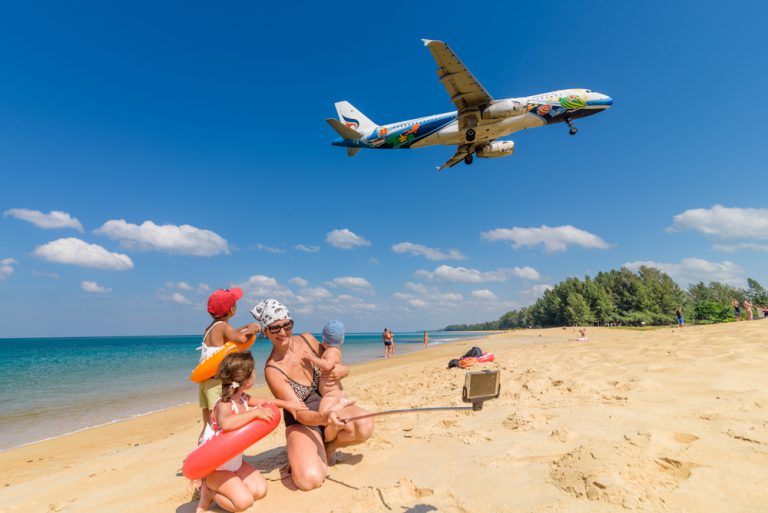 Family taking a picture, airplane in the background