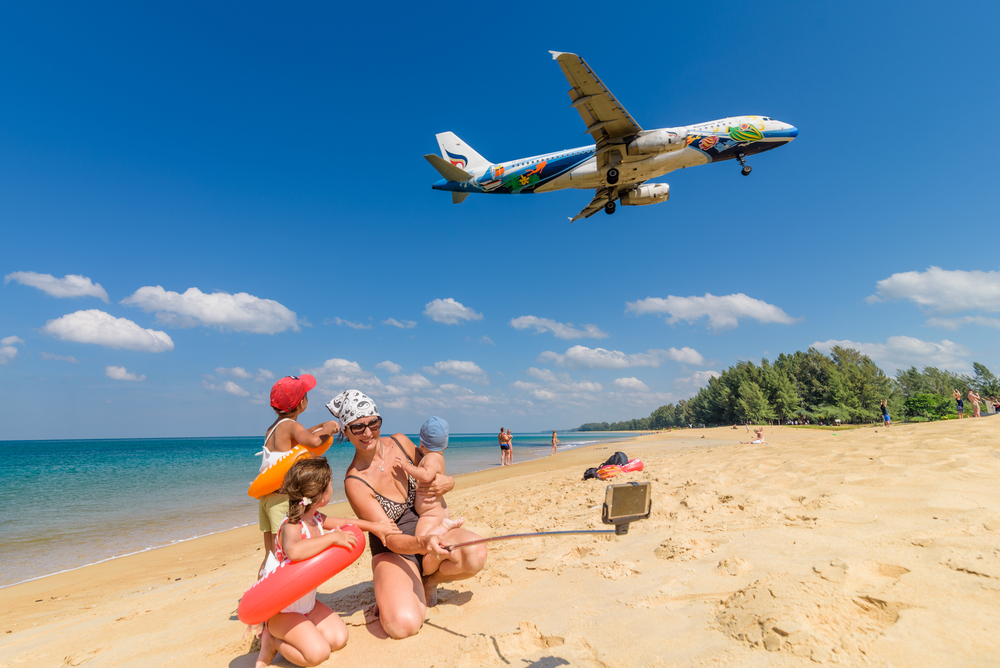 Family taking a picture, airplane in the background