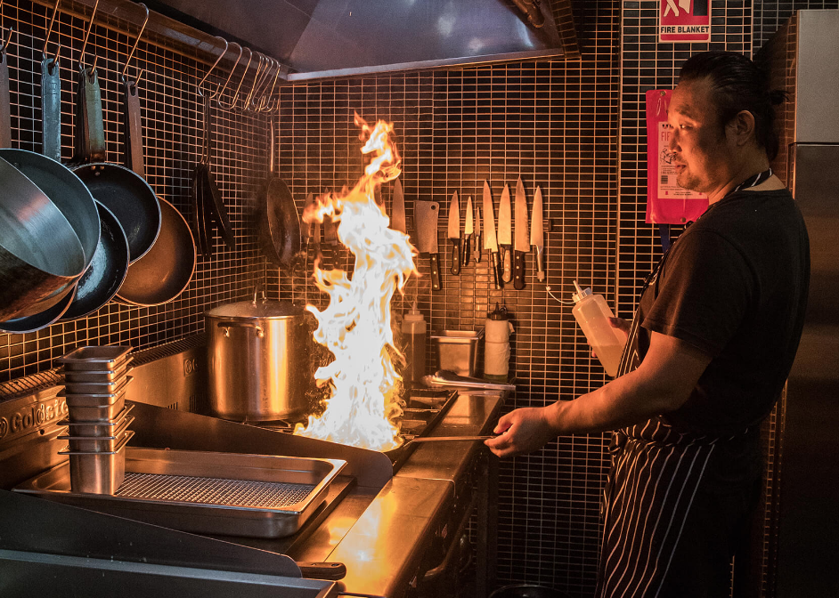 A chef flambeing while cooking