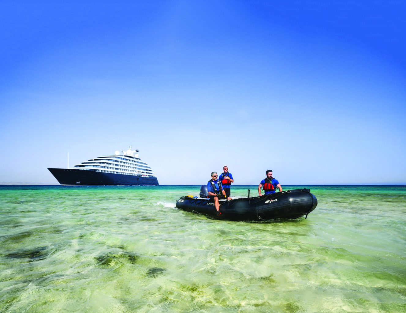 a boat with 3 passengers and a cruise ship behind