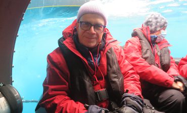 An old man wearing red jacket