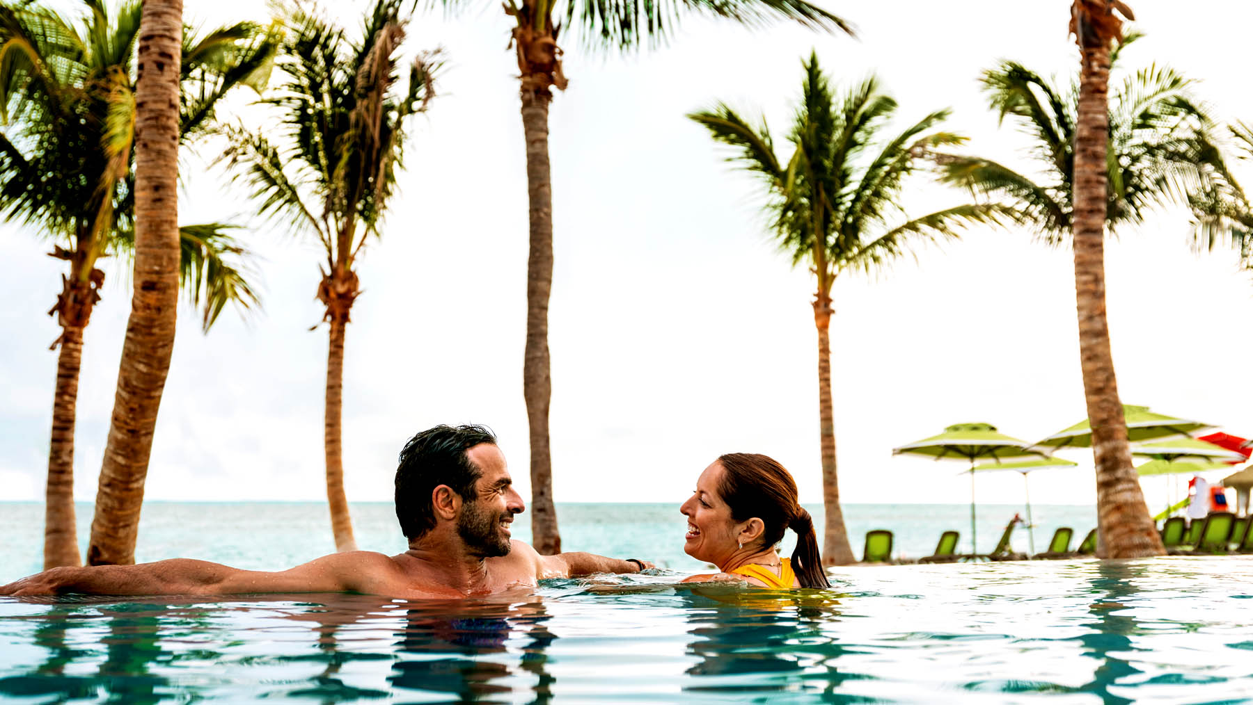 Cruise passengers spend time at the beachfront infinity pool. 