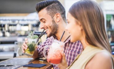 A couple drinking cocktails at a bar on a cruise ship P&O Cruises