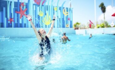 A child splashes around in a pool while Royal Caribbean prices increase.