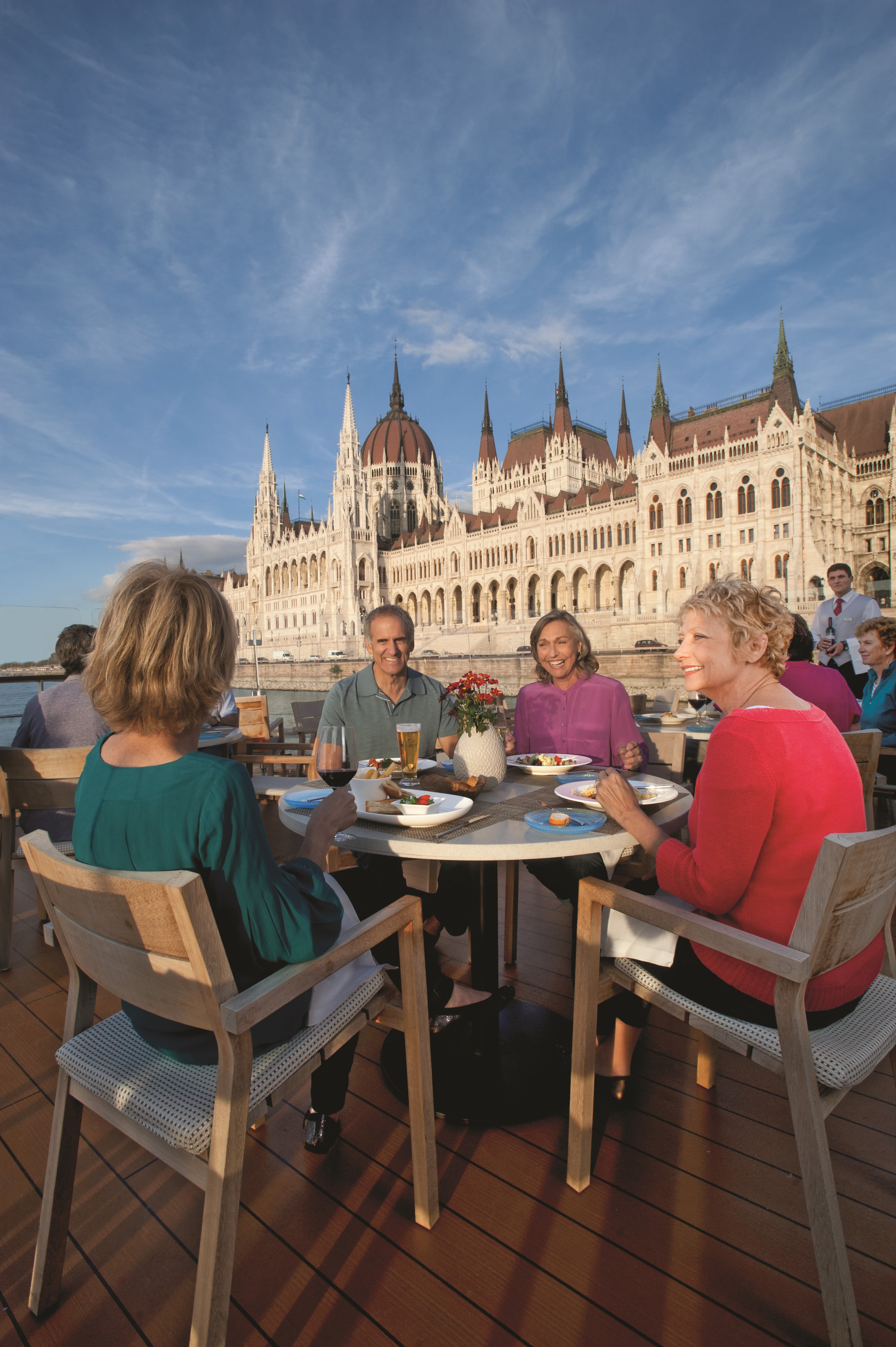 Guests enjoying a river cruise with Viking Budapest in the background
